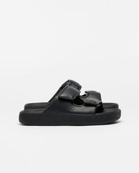 A pair of black double-strap slide sandals with a thick, textured sole, shown from a side profile against a clean white background.