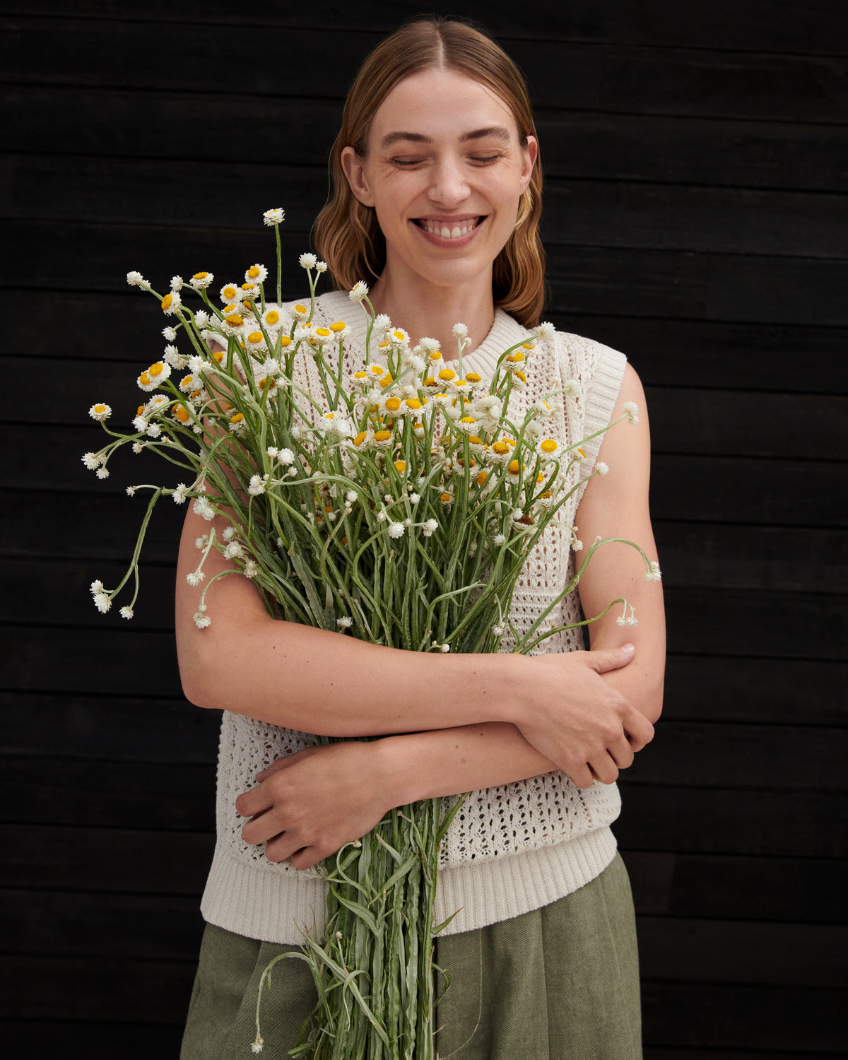 Woman holding a bouquet of flowers against a black background