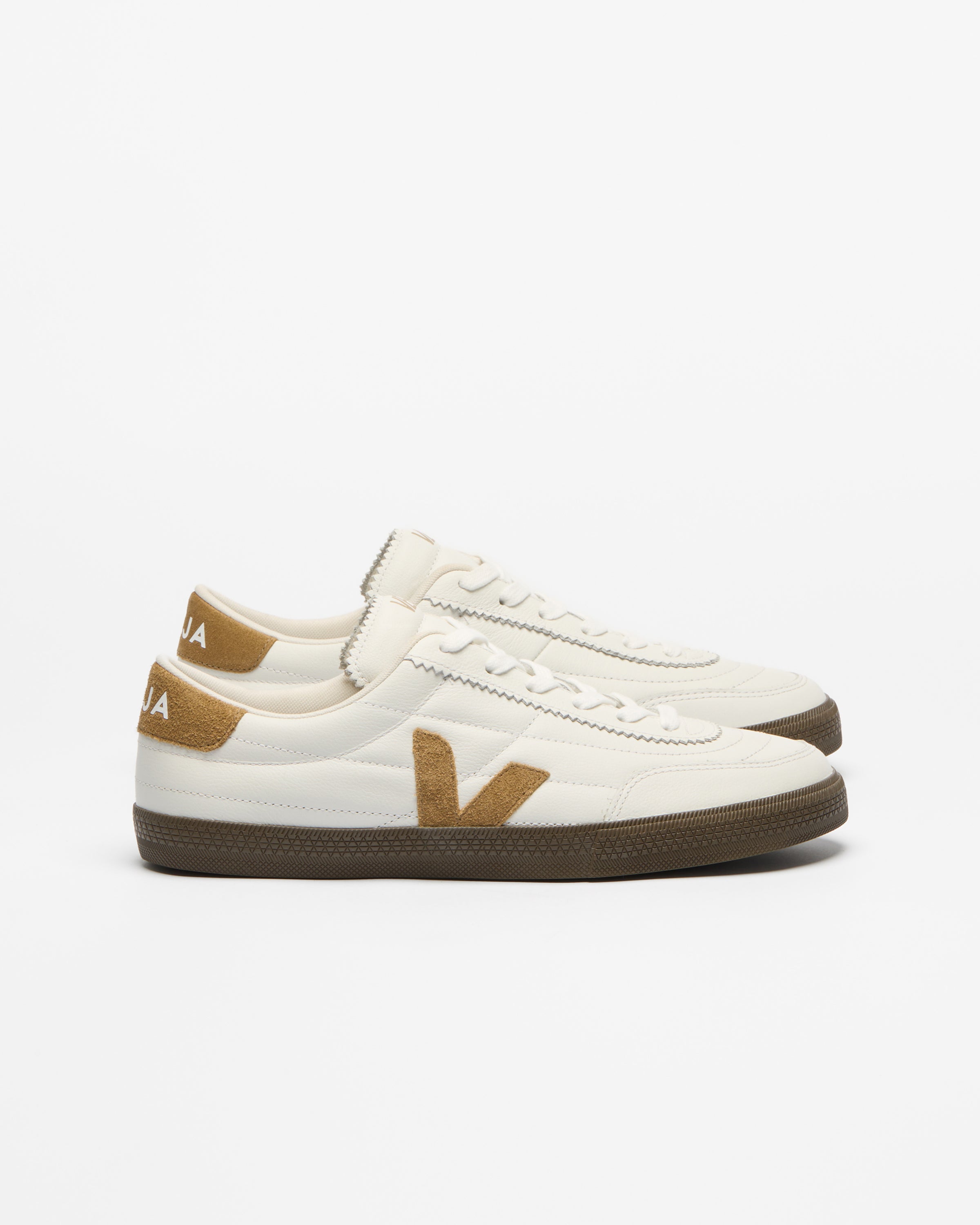 A pair of Veja low-top sneakers in off-white leather with tan suede accents and a brown rubber sole.
