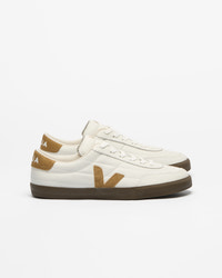 A pair of Veja low-top sneakers in off-white leather with tan suede accents and a brown rubber sole.
