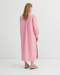 A women wearing a button up pink dress.