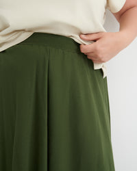 Green skirt worn by a person on a plain background