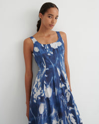 Woman wearing a blue and white tie-dye dress against a plain background