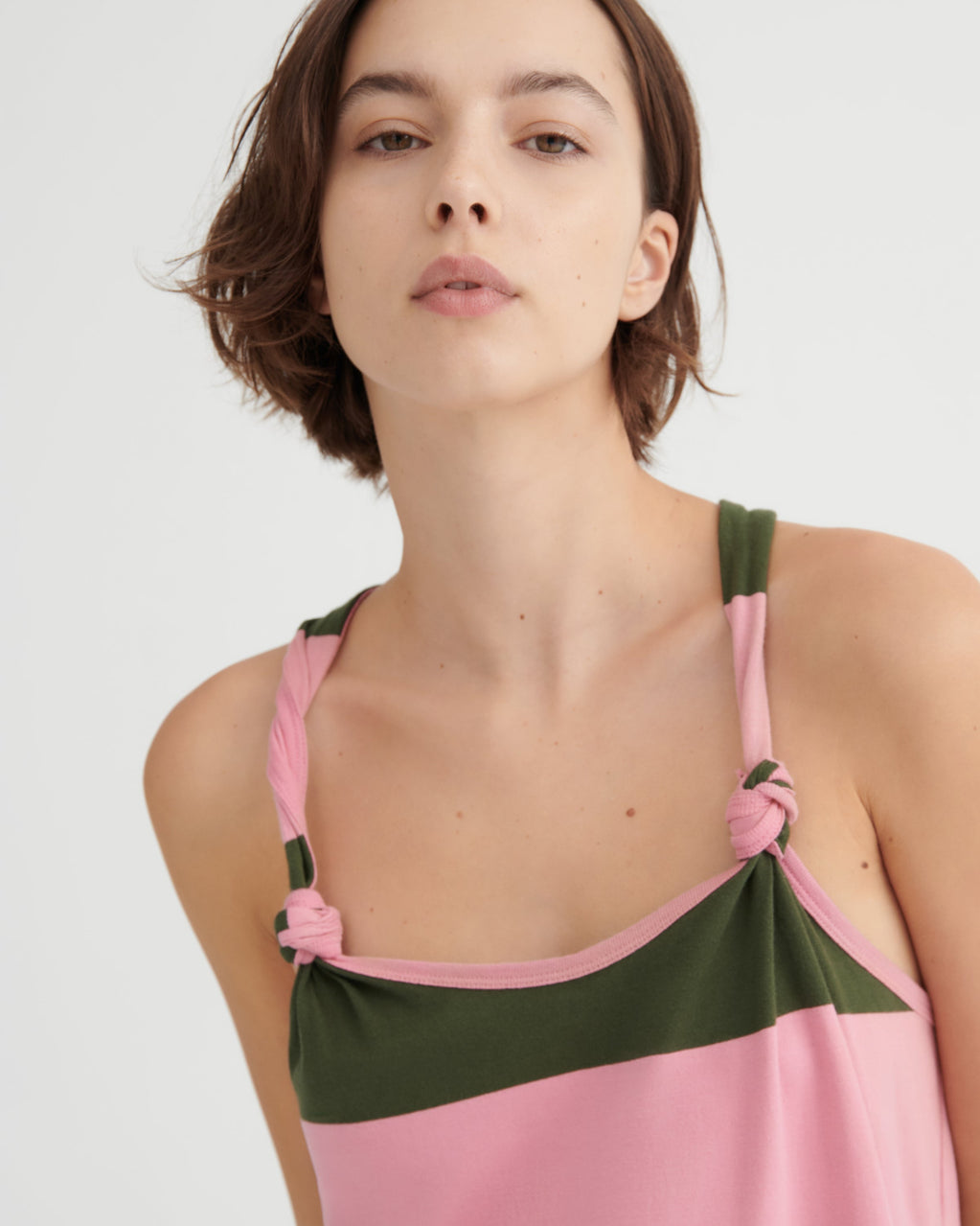 Woman wearing a pink and green dress against a white background