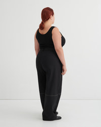Person wearing a black singlet and pants against a white background