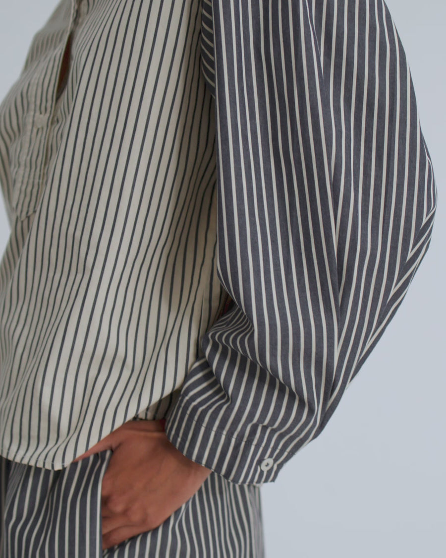 A women wears a striped shirt and matching striped shorts.