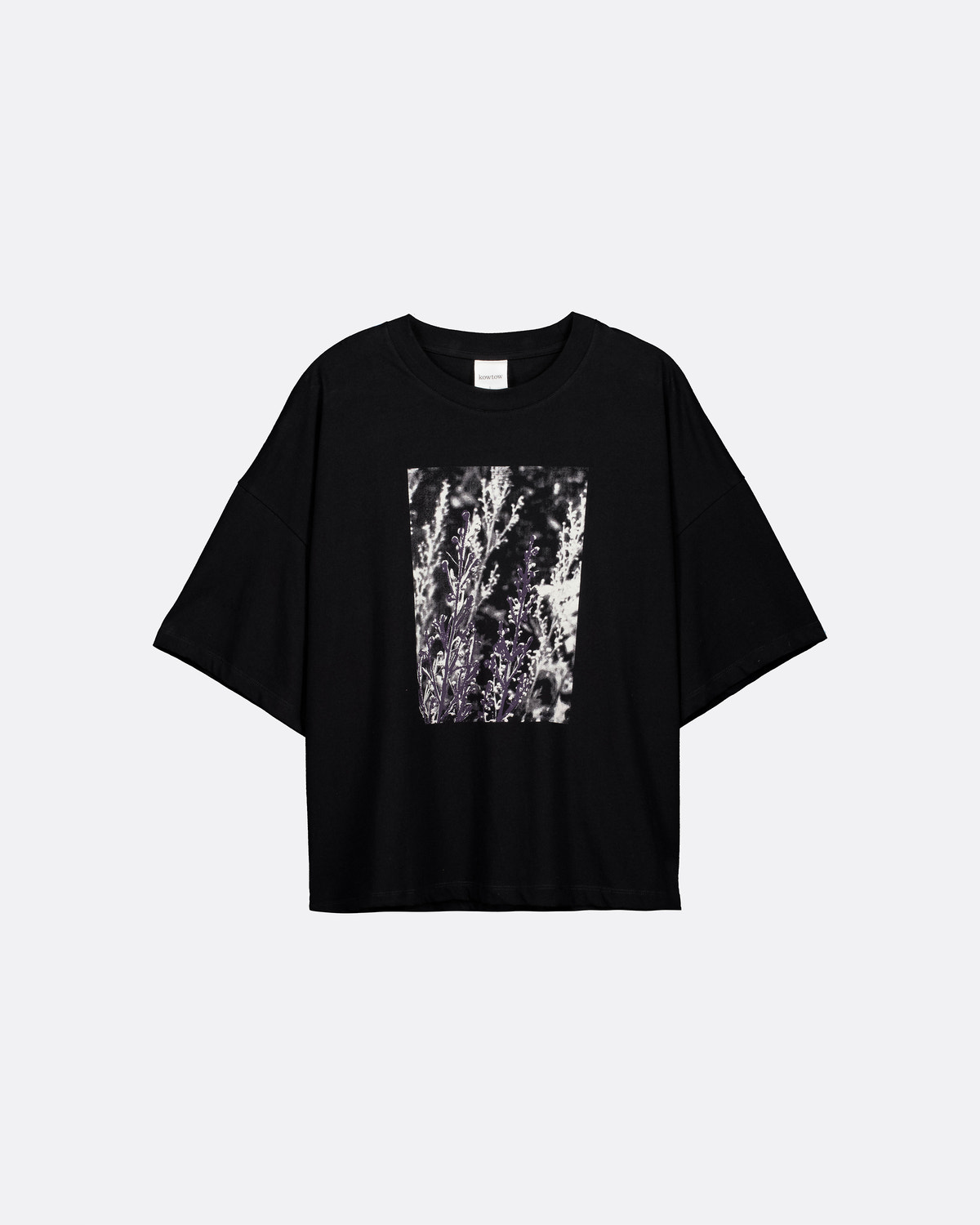 A black short-sleeve t-shirt with a square abstract graphic print in black, white, and gray on the front, displayed against a light gray background.